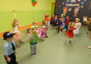Sala gimnastyczna. Dzieci w przebraniach tańczą podczas balu karnawałowego. W tle dekoracja tematyczna.