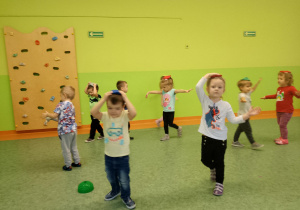Sala gimnastyczna. Dzieci wykonują ćwiczenia gimnastyczne.