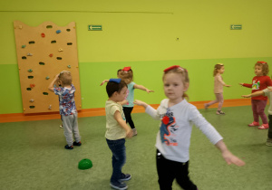 Sala gimnastyczna. Dzieci wykonują ćwiczenia gimnastyczne.