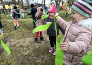 Ogród przedszkolny. Dzieci tańczą z szarfami z zielonej bibuły.