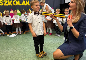 Chłopiec podczas pasowania na przedszkolaka przez Panią Dyrektor.