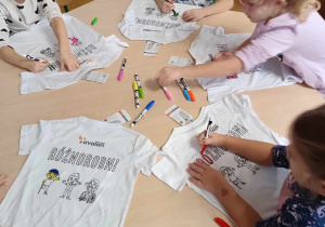 Dzieci ozdabiają koszulki z napisem "Różnorodni"