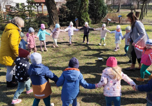 Dzieci podczas zabawy w kole, w ogrodzie przedszkolnym.