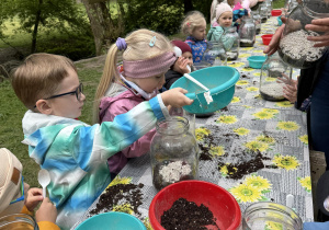 dzieci podczas warsztatów botanicznych wykonują las w słoiku