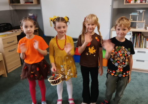 Dzieci pozują do zdjęcia w jesiennych strojach