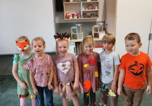 Dzieci pozują do zdjęcia w jesiennych strojach