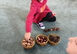 Dziewczynka układa rytm z darów jesieni