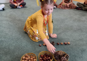 Dziewczynka układa rytm z darów jesieni