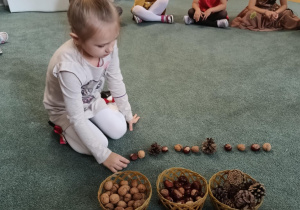 Dziewczynka układa rytm z darów jesieni