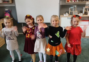 Dziewczynki pozują do zdjęcia w jesiennych strojach