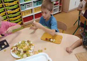 Chłopiec podczas przygotowywania owocowego szaszłyka