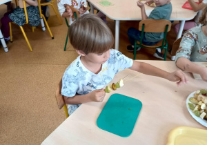 Chłopiec podczas przygotowywania owocowego szaszłyka