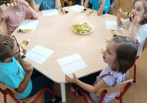 Dzieci zajadają się samodzielnie przygotowanymi szaszłykami owocowymi