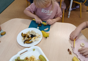 Dziewczynka kroi śliwkę