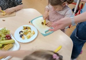 Dziewczynka kroi śliwkę