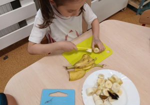 Dziewczynka kroi banana