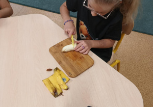 Dziewczynka kroi banana