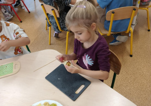 Dziewczynka podczas przygotowywania owocowego szaszłyka