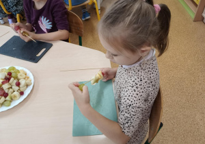 Dziewczynka podczas przygotowywania owocowego szaszłyka