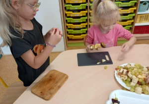 Dziewczynki podczas przygotowywania owocowych szaszłyków