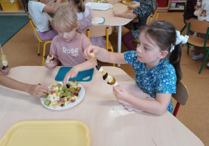 Dziewczynki podczas przygotowywania owocowych szaszłyków