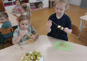 Dziewczynki podczas przygotowywania owocowych szaszłyków
