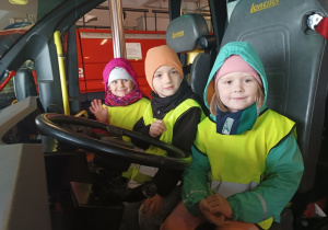 Dzieci siedzące w wozie strażackim
