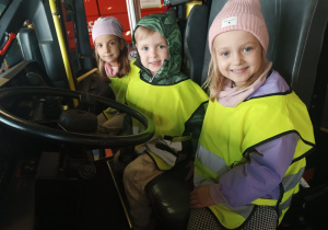 Dzieci siedzące w wozie strażackim
