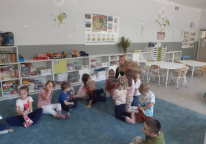 Dzieci słuchające książki czytanej przez jedną z mam