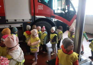 Dzieci odwiedzające straż pożarną podczas wycieczki na lotnisku