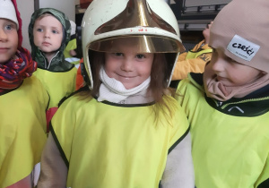 Dziewczynka przymierzająca hełm strażacki