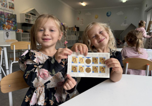 dzieci oglądają znaczki pocztowe