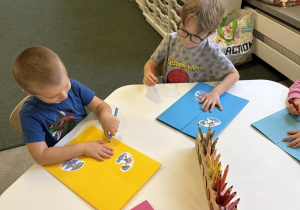 dzieci wykonują lapbook o jesiennej pogodzie