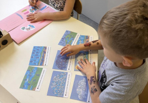 dzieci wykonują lapbook o jesiennej pogodzie