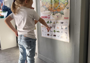dziewczynka przy plakacie z mapą Polski