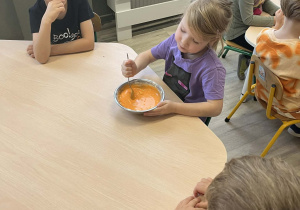 Dzieci przy stoliku mieszają magiczną farbę w metalowej misce