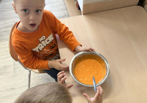 Chłopcy mieszający magiczną farbę w metalowej misce