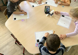Dzieci podczas wykonywania własnej pocztówki przy stolikach