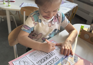 dzieci wyklejają i kolorują książeczkę o prawach dziecka