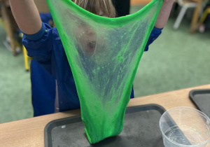 Dziewczynka rozciąga zielonego slime