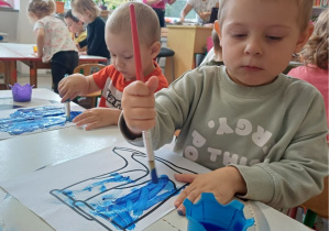 chłopiec maluje farbami obrazek