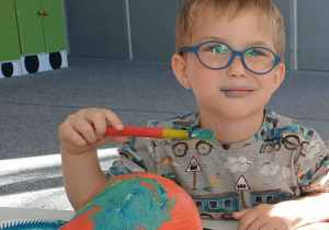 dziecko ozdabia dynię