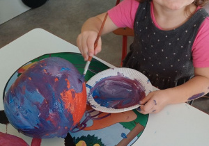 dziecko ozdabia dynię