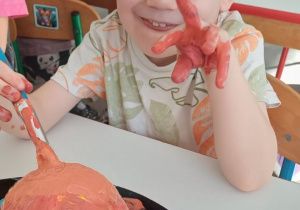 dziecko ozdabia dynię