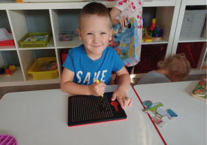 chłopiec tworzy obrazki magnetyczne