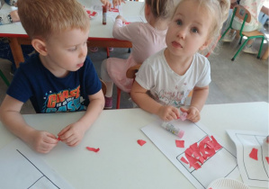 dzieci wydzierają kartki i naklejają na flagę