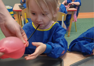 dziewczynka dmucha balonika