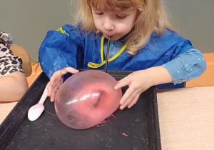 dziewczynka dmucha balonika