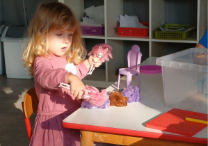 dziewczynka bawi się laleczkami