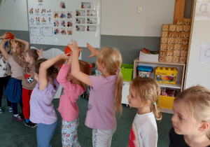 Dzieci podają sobie dynię nad głowami